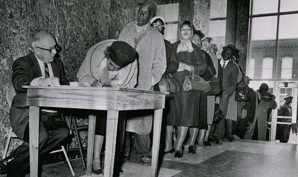 Photograph of African Americans standing in a line waiting to register to vote