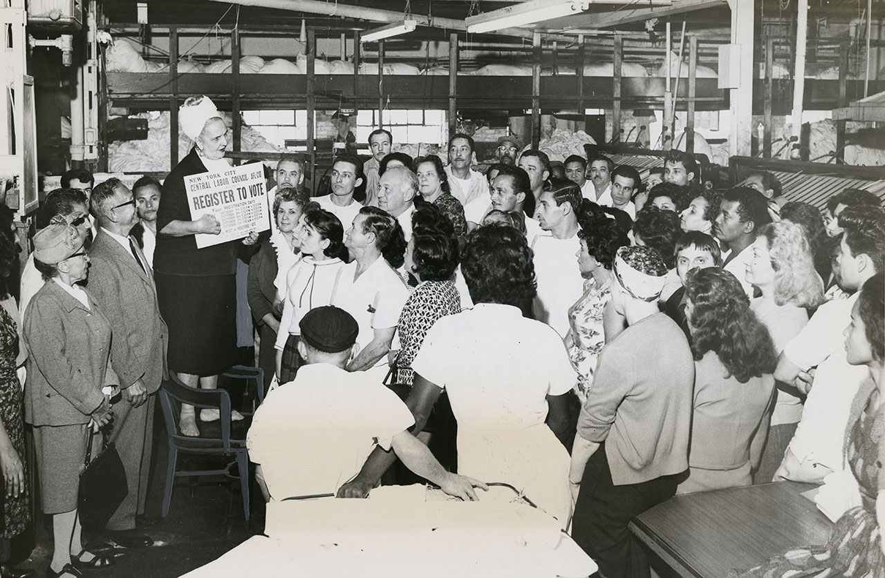 Woman speaking to laborers about voting