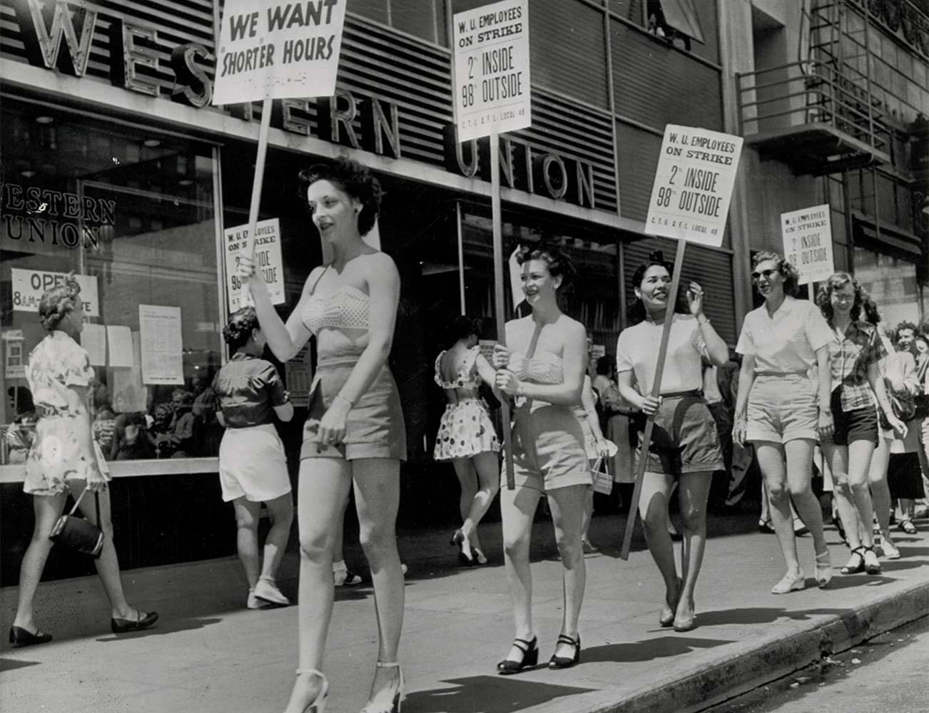 Strikers picketing in shorts to bring attention to their demand for shorter hours, United Telegraph Workers Local 48