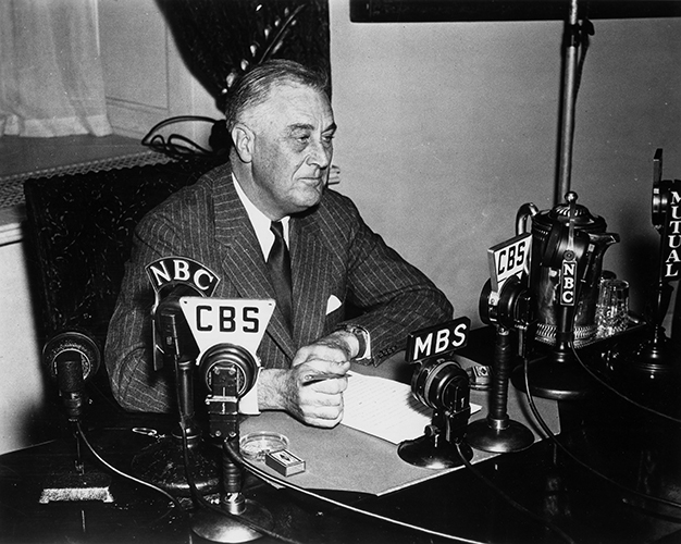 Franklin Delano Roosevelt seated behind desk during a fireside chat
