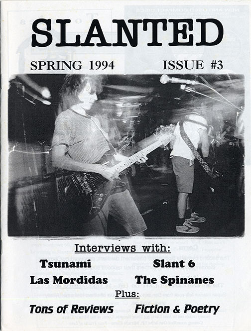 Black and white cover page with 'SLANTED' in a large typwriter-like font above a photograph of Kristin Thomson of Tsunami playing a guitar onstage.