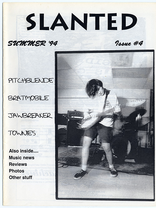 Black and white zine cover with title in bold black text with a large photograph of Erin Smith of the Band Bratmobile playing a Vox MKIII teardrop electric guitar.